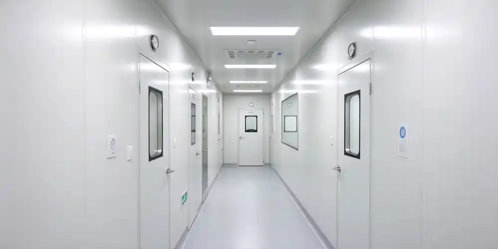 EU GMP Grade B cleanroom corridor with white walls, observation windows and circular differential pressure gauges