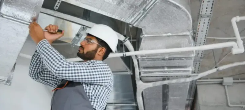 HVAC contractor checking ductwork before installing a HEPA filter HVAC contractor checking ductwork before installing a HEPA filter