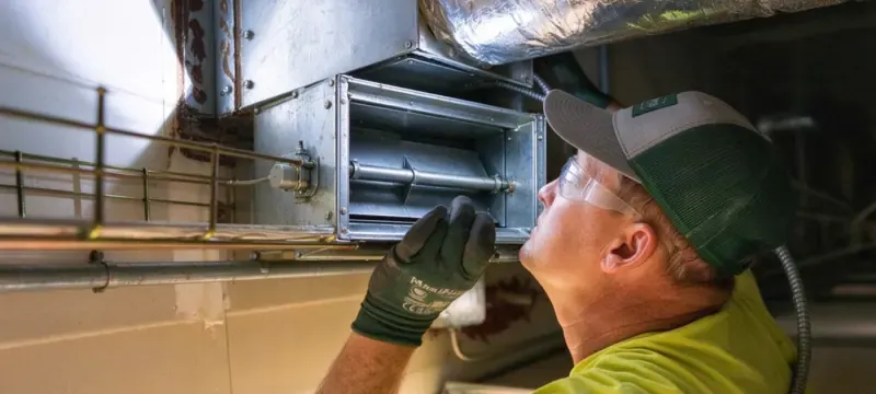 HVAC engineer inspecting duct damper on site