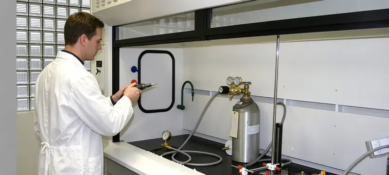 Laboratory technician performing tracer gas containment test on fume hood Laboratory technician performing tracer gas containment test on fume hood