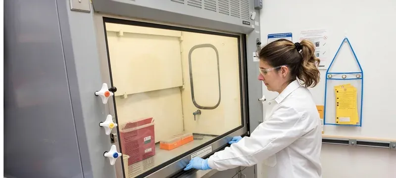 Laboratory technician checking fume hood sash height and airflow reading before starting work Laboratory technician checking fume hood sash height and airflow reading before starting work