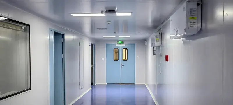 Cleanroom corridor in a pharmaceutical facility with sealed door leaves set into wall panels