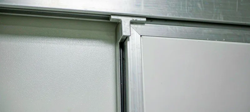 Flush integration detail of cleanroom door frame and wall panel